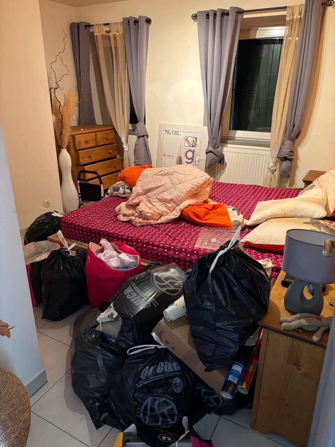 Chambre encombrée de sacs et objets avant débarras